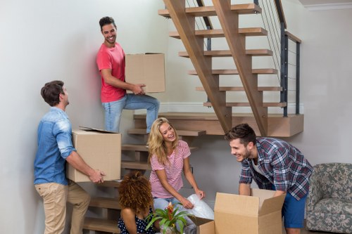 Local movers carrying items through a residential building