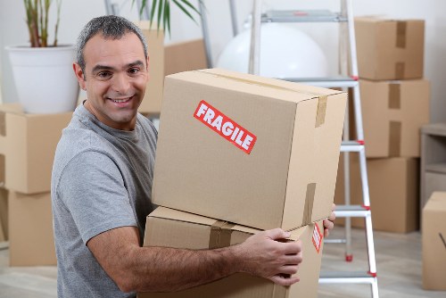 Specialist piano removals team moving an upright piano in a North Sheen home