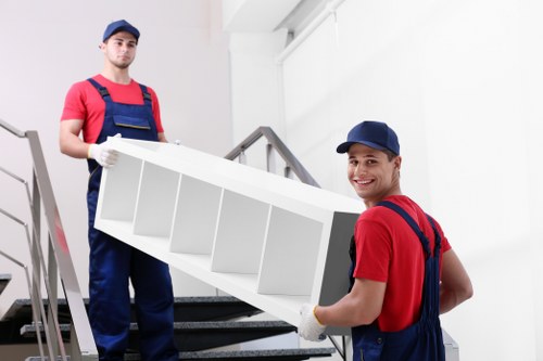 Residential moving team handling boxes and furniture near North Sheen