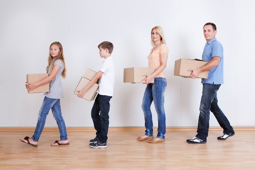 Professional movers loading items into a removals van in West London