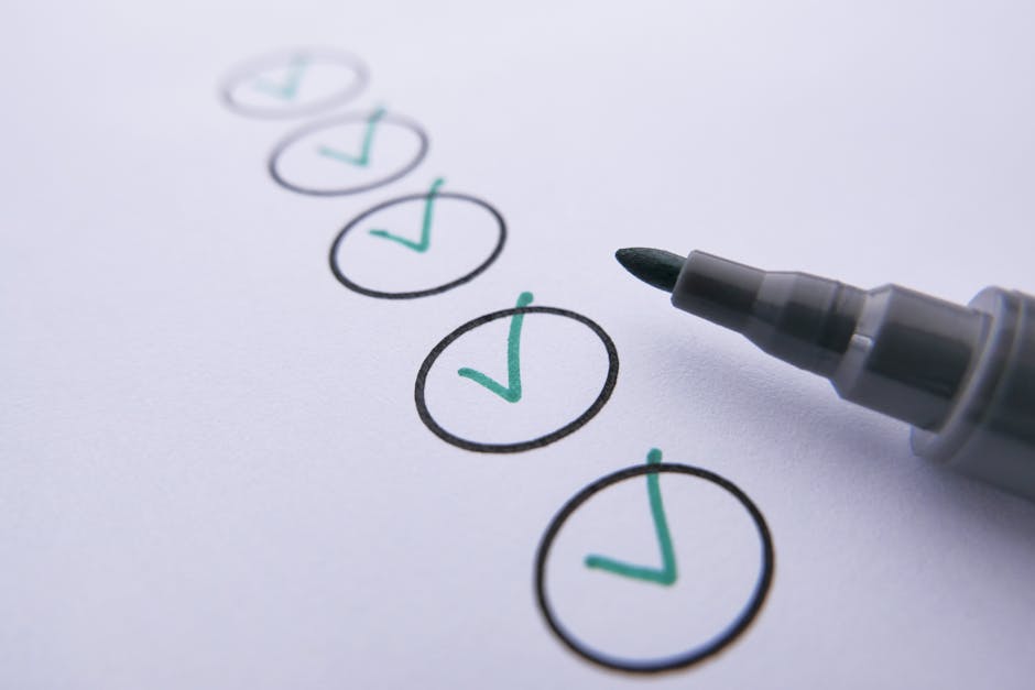 Close-up image of a white sheet of paper with a series of six hand-drawn circles outlined in black ink, each containing a green check mark. The circles are arranged vertically, and the photograph captures the lower right corner of the paper along with a black marker pen, which is positioned as if recently used to mark the checks. The background is plain and out of focus, emphasizing the checked items on the paper. This visual could relate to planning, checklists, or organisation processes involved in house removals or home relocation services. Man and Van North Sheen may use such checklists to ensure all packing, moving, and loading tasks are completed efficiently during furniture transport and logistics for clients relocating from Mortlake to North Sheen.